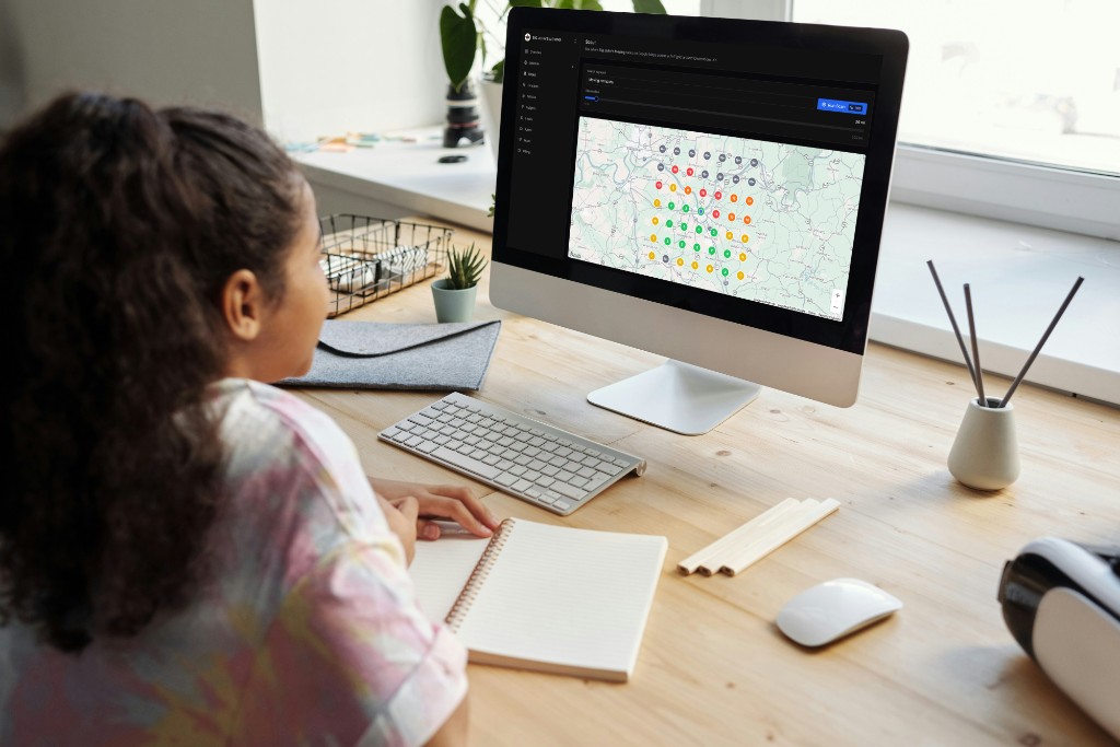 Person at a desk viewing Scout’s local SEO heatmap — Google Maps ranking grid on screen